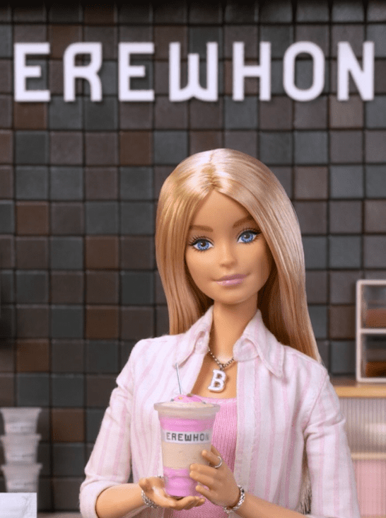 Poupée Barbie tenant un smoothie Erewhon à l'intérieur d'un magasin Erewhon, dans le cadre de la collaboration de marque Erewhon x Barbie