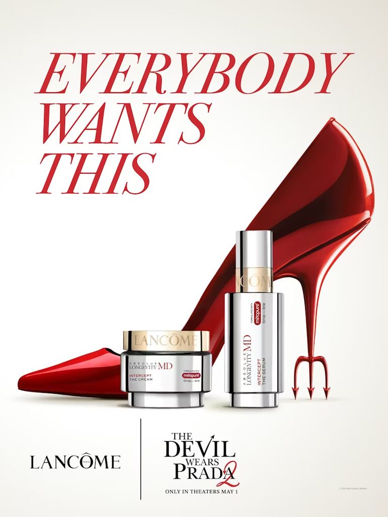 Affiche officielle de la collaboration Lancôme x The Devil Wears Prada 2 mettant en vedette la gamme Absolue Longevity MD aux côtés d'un escarpin rouge et d'une fourche diabolique, avec le slogan « Everybody Wants This »